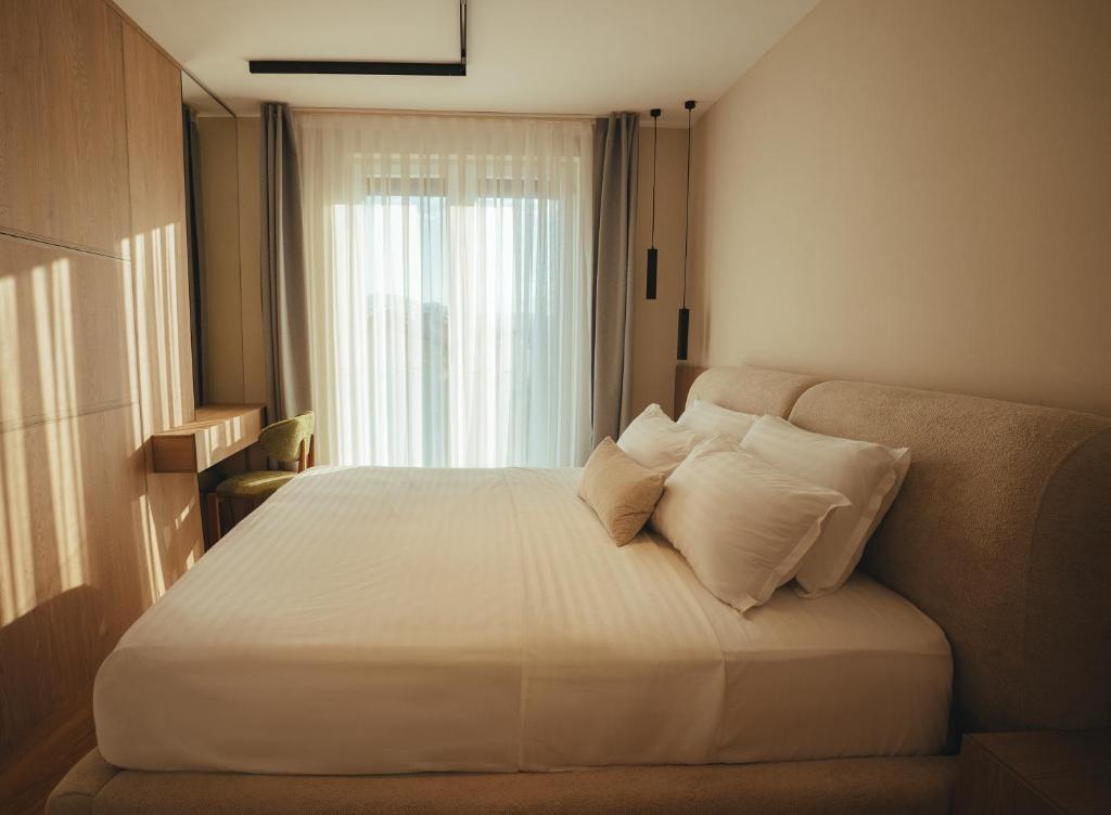 Soft morning light across a king bed by a tall window