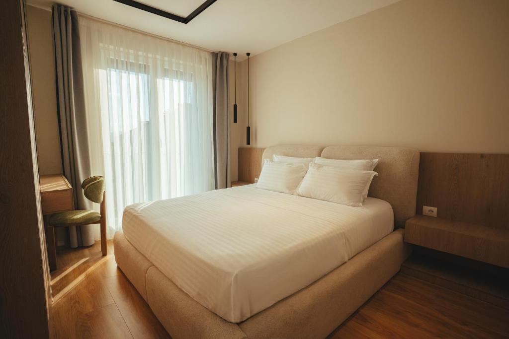 King bed framed by floor-to-ceiling sheer curtains