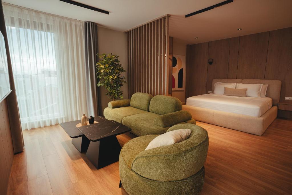 Suite lounge with green velvet sofas and king bed